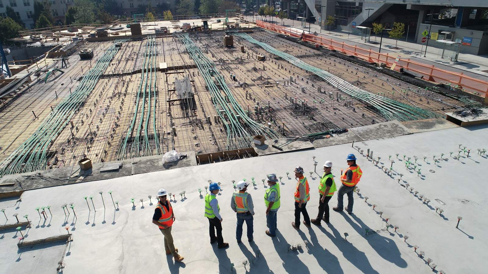 Workers in high-visibility clothing on a large construction site.
